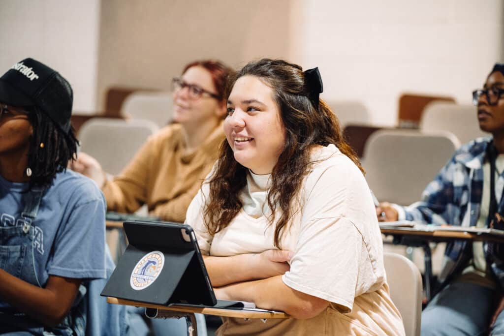 Music student smiling and listening to a lecture.