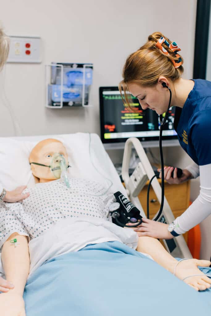 Nursing student working with sim man
