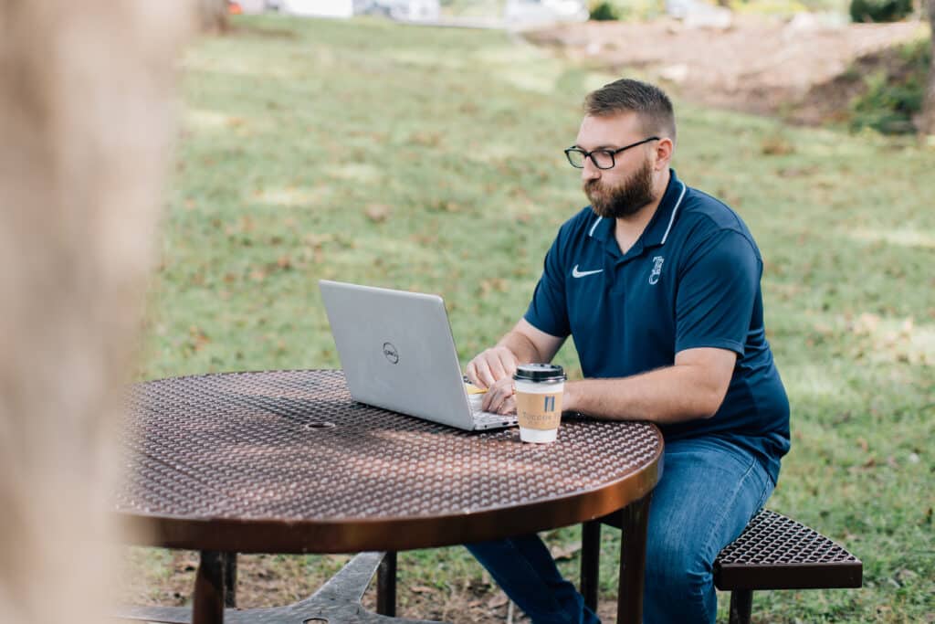 Student working on laptop outside