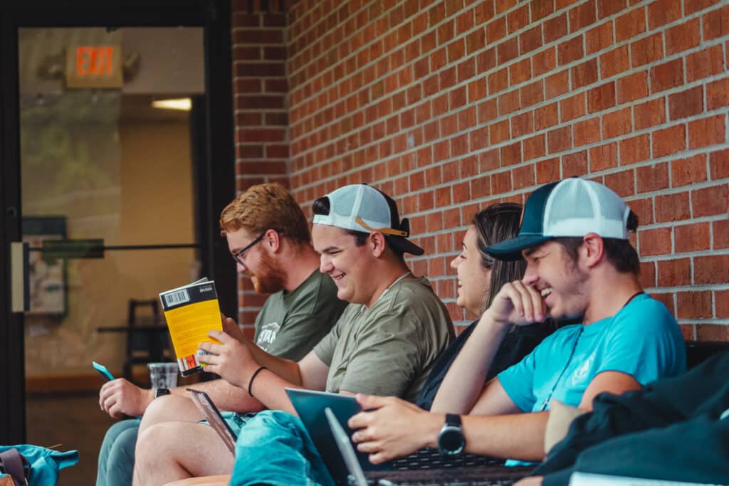 Toccoa Falls College students laughing outside of building