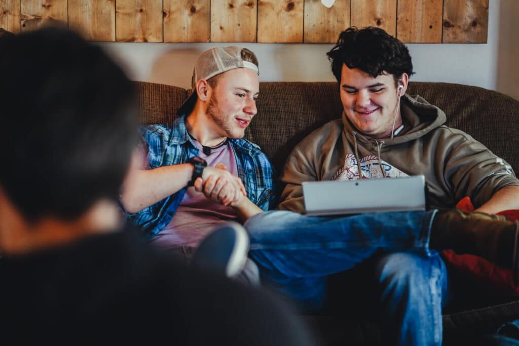 students sitting on couch looking at a laptop