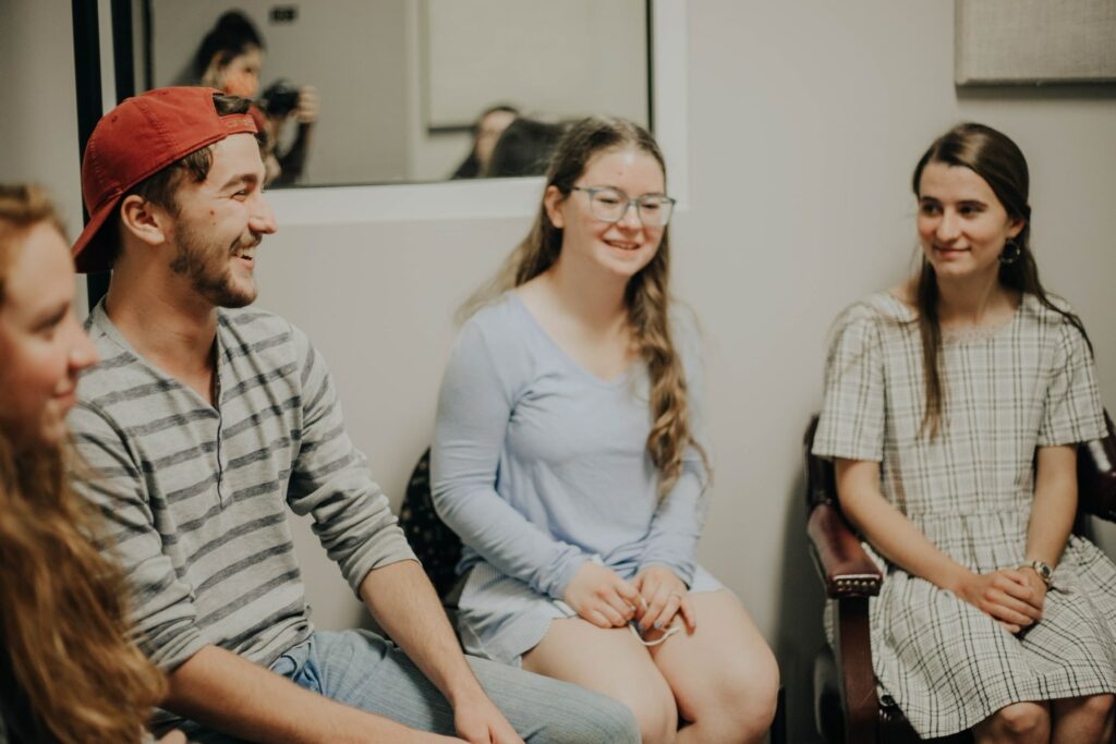 Group of young people smiling and talking in a circle