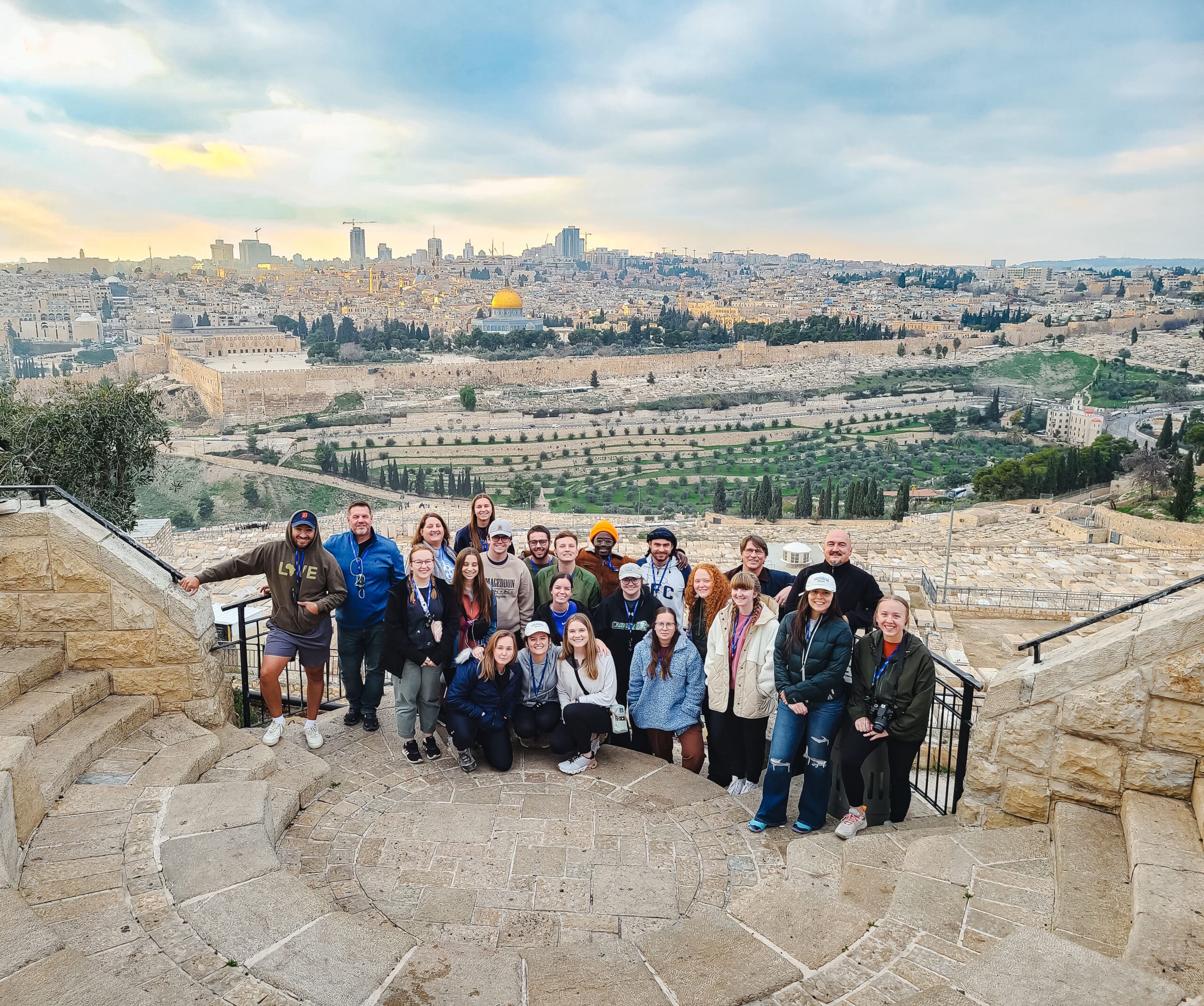 Toccoa Falls students and professors stand on stone steps, overlooking an ancient city