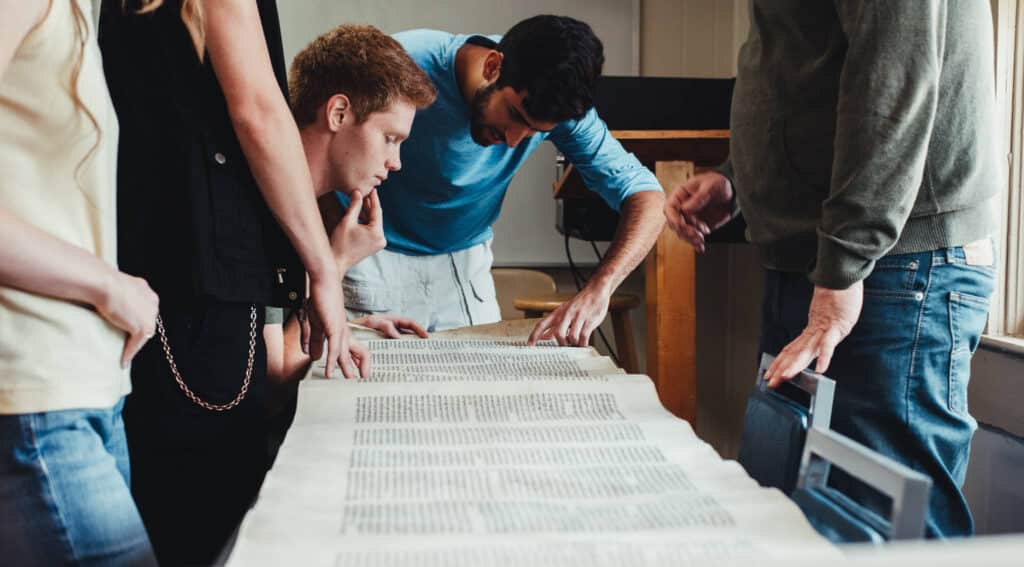 Biblical Studies students looking at a scroll