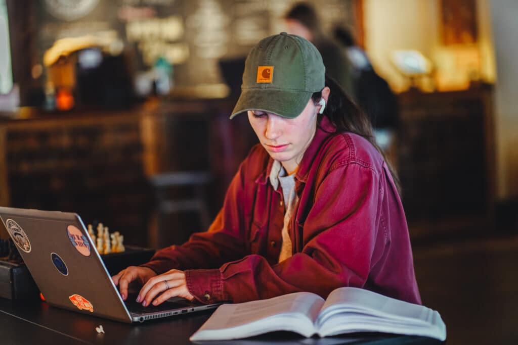 Student studying with book and laptop